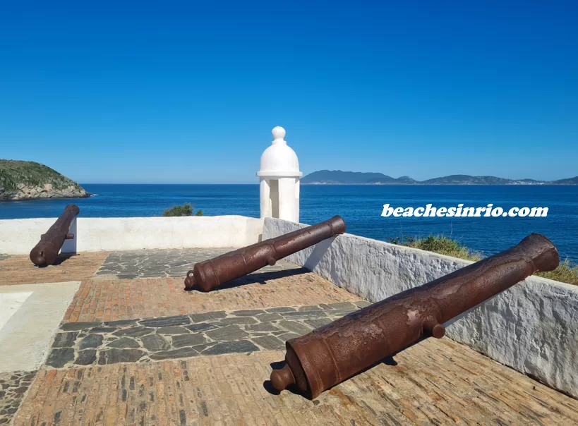 Historic São Mateus Fort in Cabo Frio, RJ, featuring a colonial-era stone structure by the blue sea, with antique cannons and a coastal sentry tower overlooking the shoreline.
